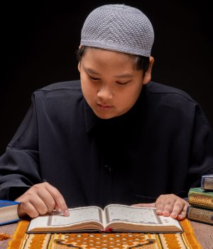 vecteezy a little asian muslim boy is sitting and reading the quran 52112766 scaled