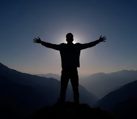 vecteezy a man standing on top of a mountain with his arms outstretched 68340370 scaled